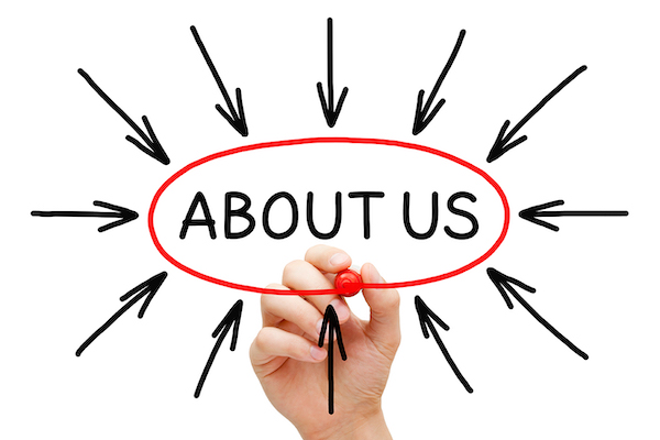 The phrase 'About Us' circled on an interactive board by a hand holding a marker